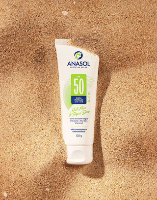 Bisnaga de 120g do Protetor Solar Corporal Anasol FPS 50 oil free e toque seco deitada sobre a areia