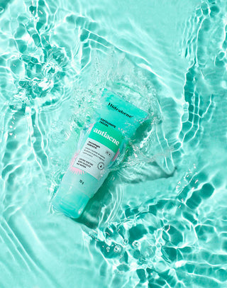 Bisnaga do Esfoliante Facial Antiacne Hidrabene sobre água turquesa