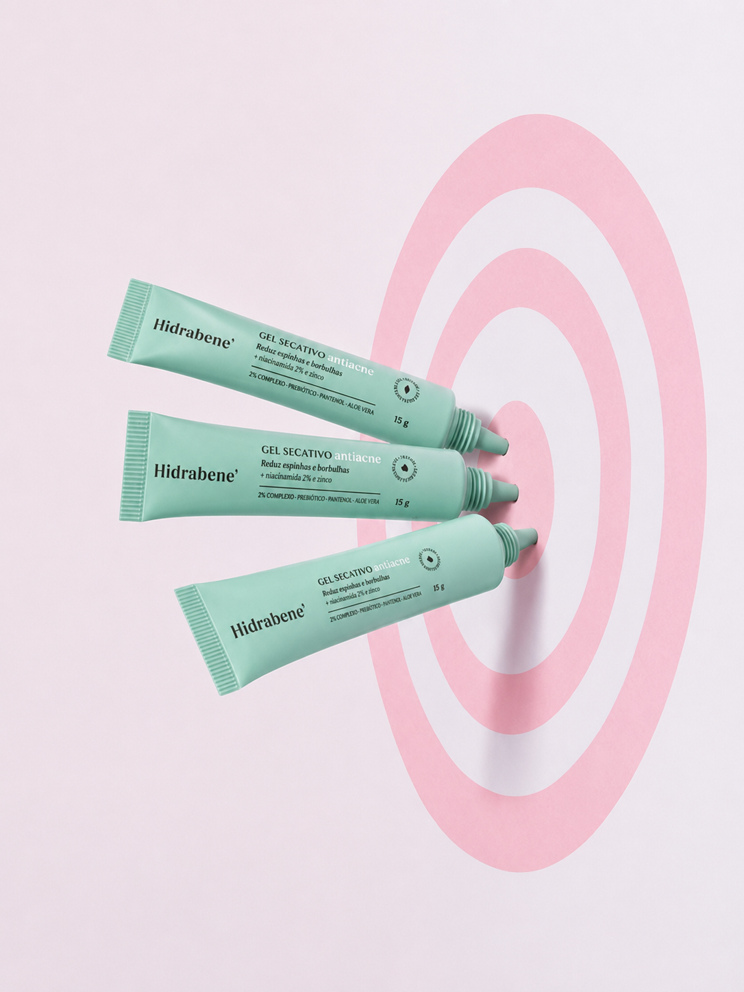 Três bisnagas do Gel Secativo Antiacne Hidrabene sobre alvo rosa
