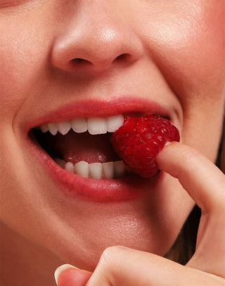Lábios corados com o Lipstick Frutas Vermelhas Hidrabene em close com framboesa