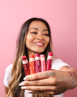 Mulher mostrando as cores da linha Lipstick Hidrabene