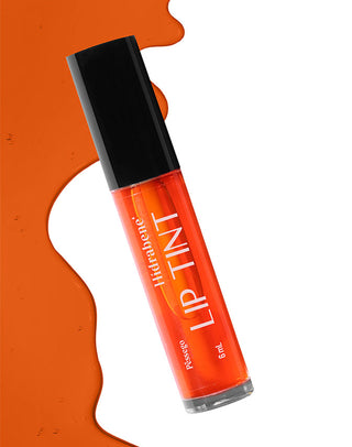 Frasco do Lip Tint Pêssego Hidrabene sobre mancha de tint laranja