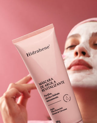 Mulher com a Máscara de Argila Revitalizante Hidrabene aplicada no rosto segurando a bisnaga