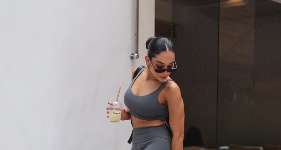 Mulher em roupa de treino caminhando na rua