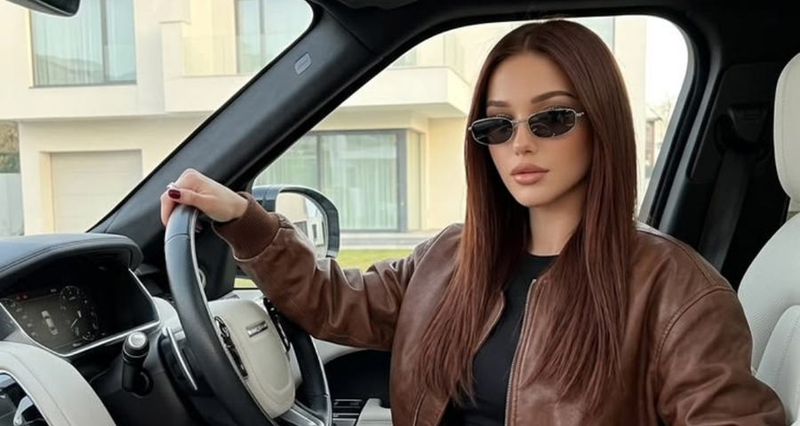 Mulher ao volante do carro, de óculos escuros