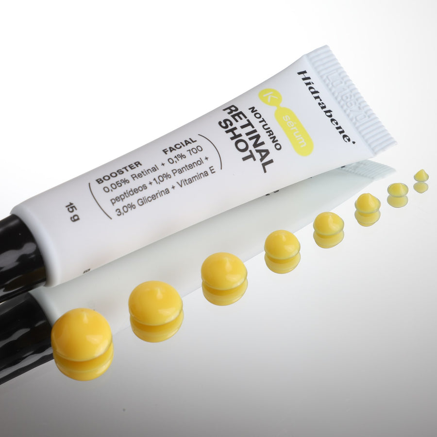 Bisnaga do Retinal Shot deitada, com gotas amarelas do produto em fila
