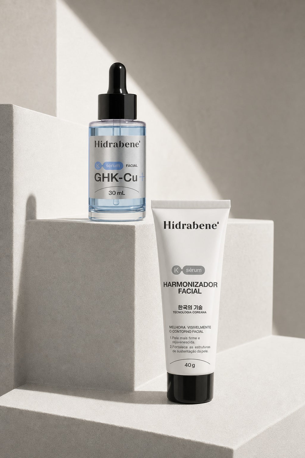 O Sérum Facial GHK-Cu e a bisnaga do Harmonizador Facial em degraus de pedra clara, sob luz do sol