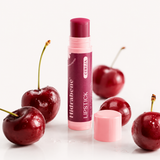 Lipstick Cereja Hidrabene 5g aberto entre cerejas frescas